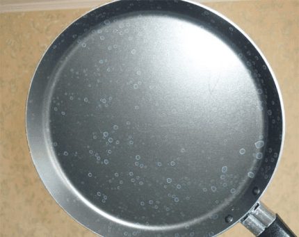 Depunere albă calcaroasă pe fundul tigăii Depunere albă pe tigaie