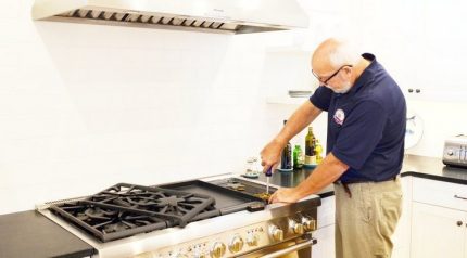 Специалист поправя газова печка
