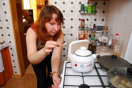 Жена запалва горелка с кибрит
