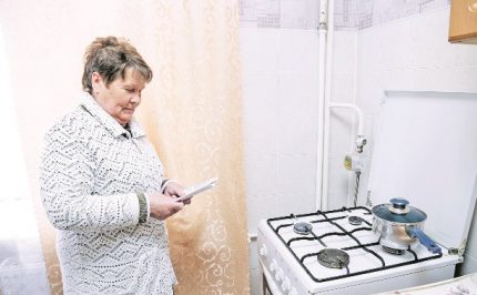 Абонатът изучава акта от газовата служба преди подписването